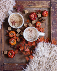 Autumn still life with a cup of coffee and autumn leaves on a wooden background