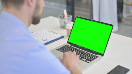Young Man Using Laptop with Chroma Screen 