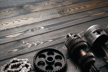 Old car spare parts on the wooden workbench background with copy space.