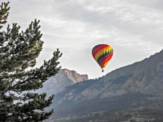 Ballon montgolfière survolant les sommets des Alpes du Sud dans les premières lueurs du soleil