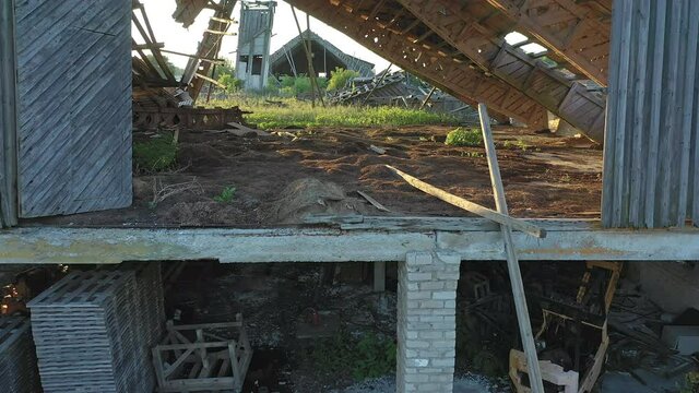 Koeru.Estonia-July 5.2021: Drone shot of a forgotten soviet farm building. Abandoned structure slowly decaying and getting taken over by nature. Camera slowly moving forward.