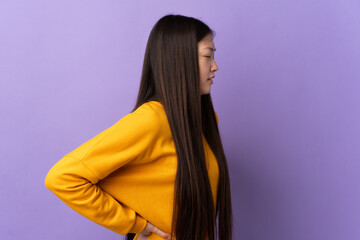 Young Chinese girl over isolated purple background suffering from backache for having made an effort