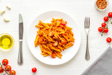 Cooked italian pasta in plate with tomato sauce and herbs