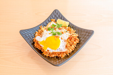 Square tray of fried nasi gore rice with egg and delicious yolk with parsley, piece of lime on...