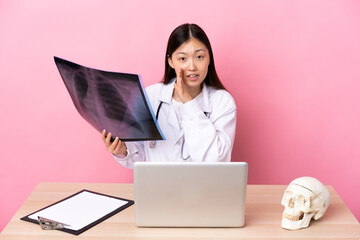 Professional Chinese traumatologist in workplace whispering something