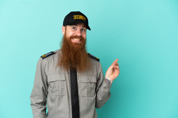 Redhead security man isolated on white background pointing finger to the side