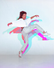 Dancing mixed race young girl in colourful light. Female dancer performer showing hip hop...