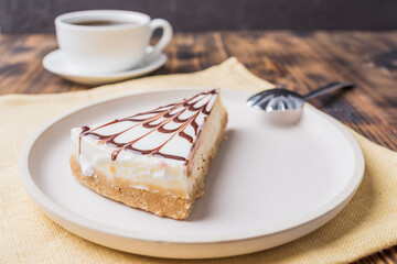 Cheesecake on a white plate with a coffee.