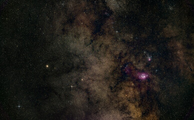 Night sky with milky way near Sagittarius constellation, bright Kaus Borealis star in lower middle, purple Lagoon and Trifid nebula visible. Long exposure stacked photo