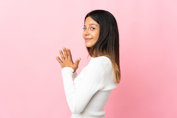 Caucasian girl isolated on pink background scheming something
