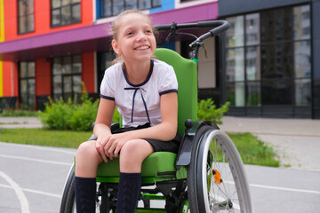 Special child on wheelchair. Girl in school uniform on the background of the school.