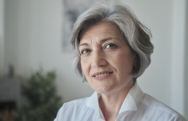 Headshot smiling and gazing at the camera, a gorgeous, confident older lady constructor smirks. A...