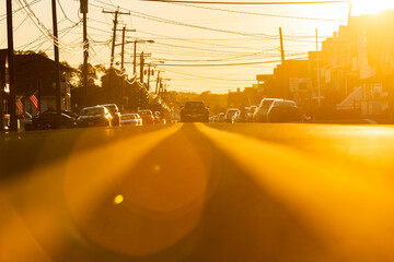 Golden hour on the double yellow lines in Manasquan, New Jersey with one moving car, telephone...
