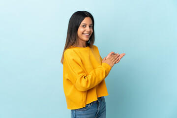 Caucasian girl isolated on blue background applauding