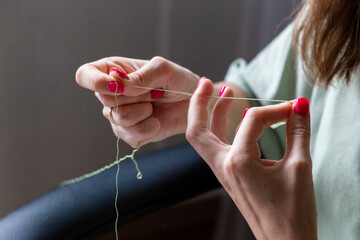 Obraz na płótnie Canvas Crafts woman holding thread in her fingers