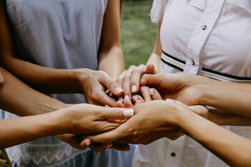 Group of women holding hands together.