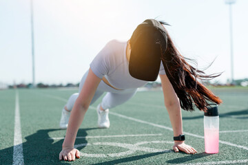  A white-skinned girl in a black cap trains standing in the bar for the next race at the stadium