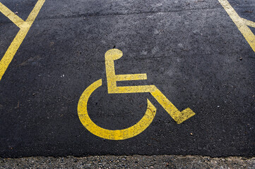 A disabled sign is painted on a parking space