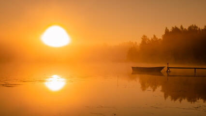Scenic misty Sunrise over lake with large orange Sun, reflection. Close up photo, copy space
