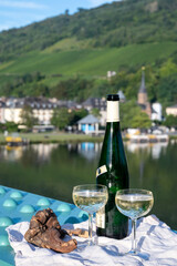 White quality riesling wine served on old bridge across Mosel river with view on old German town in sunny day