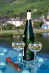 White quality riesling wine served on old bridge across Mosel river with view on old German town in sunny day