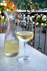Tasting of white quality riesling wine served on outdoor terrace in Mosel wine region and old German town on background, Germany