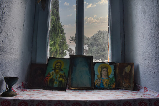 religious icons in the window of the chapel and trees in the sky in the back