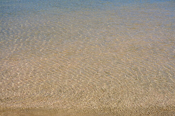 Surface of clear water on tropical sandy beach in Crete Greece.