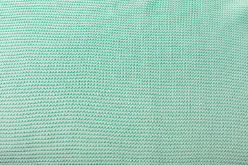 Fototapeta na wymiar Knitted texture closeup. The wrong side of a knit. Blank mint green background for layouts.