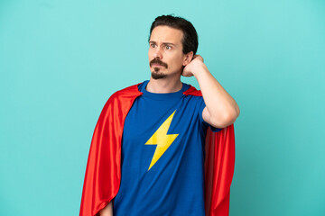 Super Hero caucasian man isolated on blue background having doubts