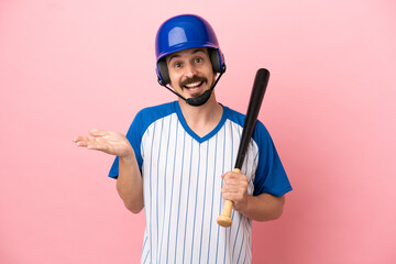 Young caucasian man playing baseball isolated on pink background with shocked facial expression