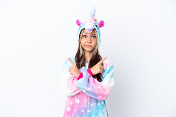 Young Russian woman wearing a unicorn pajama isolated on white background pointing to the laterals having doubts