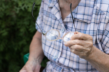 Senior woman holding glasses on her hand