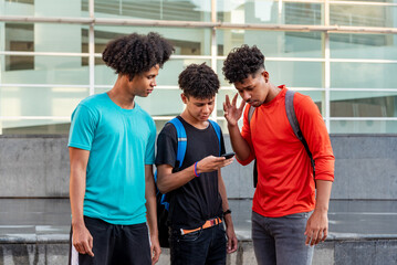 Multiethnic friends using mobile phone in the street