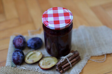Retro glass jar with a jam from plum on a desk. Food concept background. Close up, selective focus and copy space
