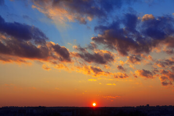 Fototapeta na wymiar Sundown over the city horizon . Spectacular clouds on the evening sky 