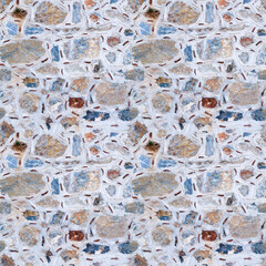 Seamless texture of wall made of multicolored stones. Asymmetric masonry. Four fragments in one.