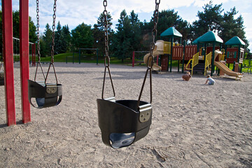 Toronto, Ontario / Canada - Sept. 12, 2014: Children play on a public playground with swing and slide