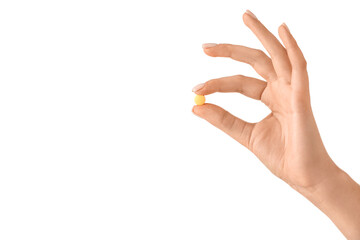 Female hand and pill on white background