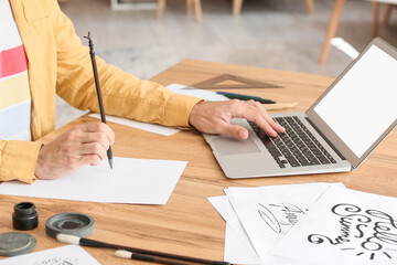 Young male calligrapher working at home