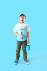 Little painter with roller and bucket on color background