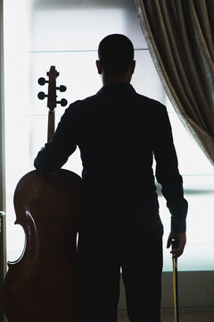 Silhueta de um violoncelista.