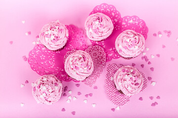 Pink cupcakes with heart shaped decorations in a pink background