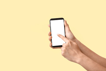 Woman using mobile phone on color background