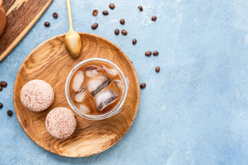 Composition with glass of tasty ice coffee and macaroons on table