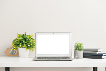 Fototapeta premium Modern laptop on table near color wall