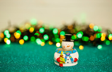 Snowman on abstract background. Christmas snowman on the table against a bokeh lights back. Snowman...