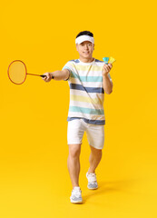 Sporty male badminton player on color background