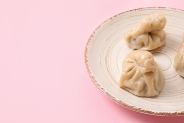Plate with tasty dumplings on color background, closeup