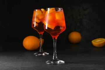 Glasses of tasty aperol spritz cocktail on dark background